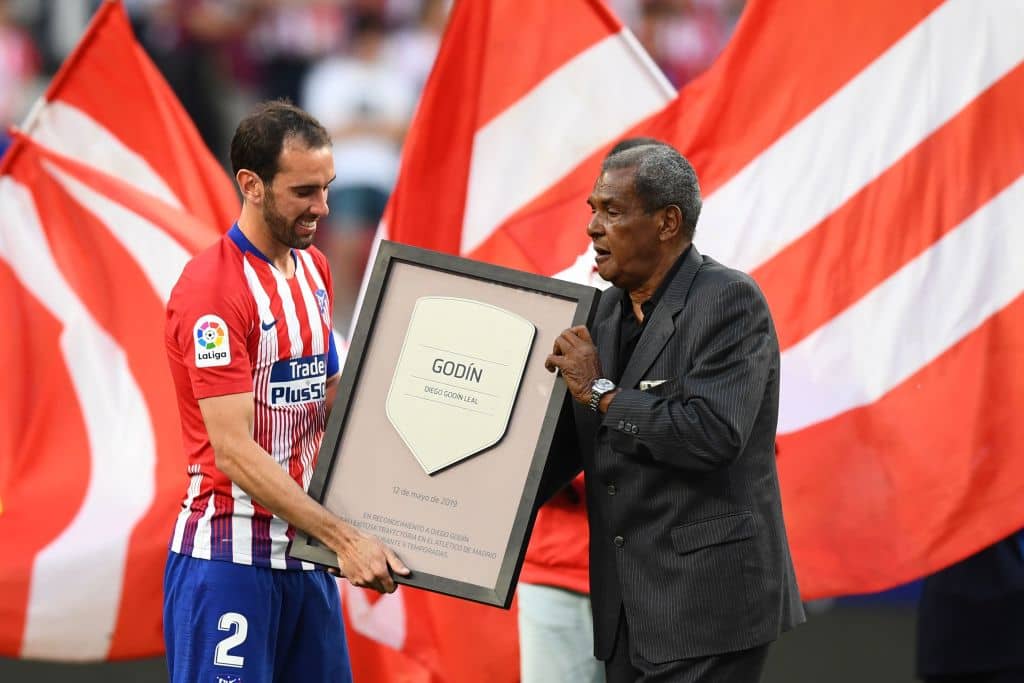 Atletico Madrid's Uruguayan defender Diego Godin received a trophy from former player Brazilian Luis Pereira after his last match with Atletico Madrid after the Spanish League football match between Atletico Madrid and Sevilla at the Wanda Metropolitan Stadium in Madrid on May 12, 2019. (Photo by GABRIEL BOUYS / AFP) (Photo credit should read GABRIEL BOUYS/AFP/Getty Images)