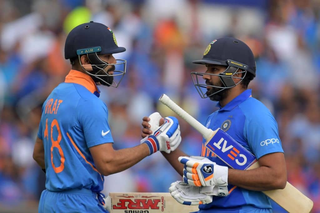 TOPSHOT - India's captain Virat Kohli (L) congratulates India's Rohit Sharma (R) as he passes him on his way back to the pavilion after losing his wicket for 103 during the 2019 Cricket World Cup group stage match between Sri Lanka and India at Headingley in Leeds, northern England, on July 6, 2019. (Photo by Dibyangshu Sarkar / AFP) / RESTRICTED TO EDITORIAL USE (Photo credit should read DIBYANGSHU SARKAR/AFP/Getty Images)