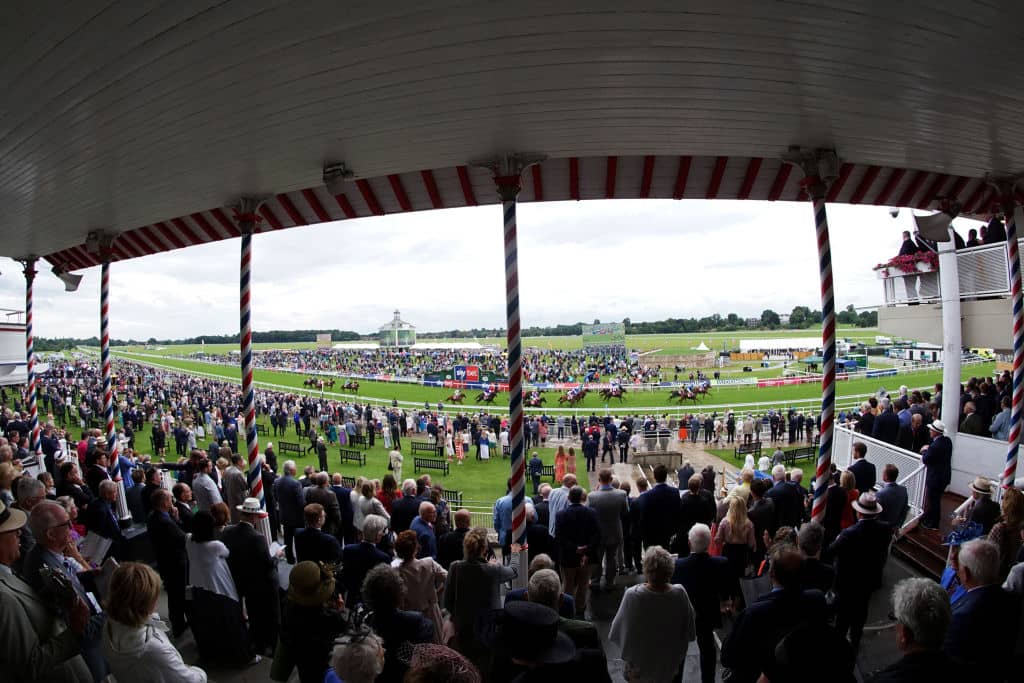 YORK, ENGLAND - AUGUST 21: (EDITOR'S NOTE: Image taken with a wide angle lens.) A general view as racegoers watch from the grandstand at York Racecourse on August 21, 2019 in York, England. (Photo by Alan Crowhurst/Getty Images)