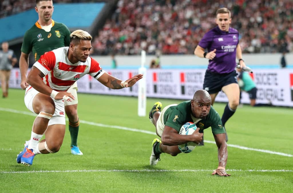 CHOFU, JAPAN - OCTOBER 20: Makazole Mapimpi of South Africa scores his team's third try past Lomano Lemeki of Japan during the Rugby World Cup 2019 Quarter Final match between Japan and South Africa at the Tokyo Stadium on October 20, 2019 in Chofu, Tokyo, Japan. (Photo by Hannah Peters/Getty Images)