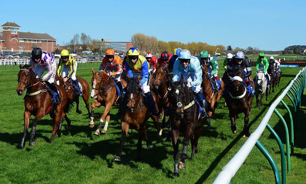 AYR, SCOTLAND - APRIL 18 : Riders bunched together on the second lap of the Coral Scottish Grand National Handicap Chase on the second day of the Scottish Grand National Festival at Ayr Race Course on April 18, 2015 in Ayr, Scotland. (Photo by Mark Runnacles/Getty Images)