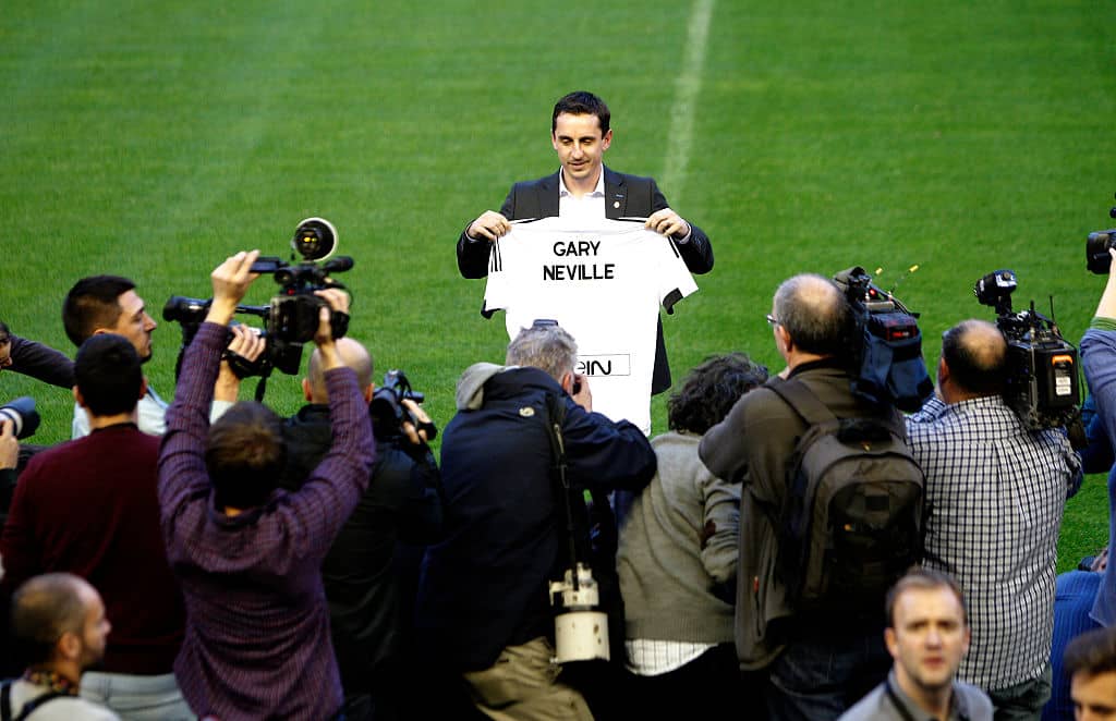 TOPSHOT - England football coach Gary Neville poses with a t-shirt during his official presentation as Valencia's new coach on December 3, 2015. Neville's appointment as Valencia boss for the remainder of the season was received with shock in Spain on Wednesday as Singaporean businessman and club owner Peter Lim attempts to protect his multi-million euro investment in the struggling La Liga side. / AFP / JOSE JORDAN (Photo credit should read JOSE JORDAN/AFP/Getty Images)